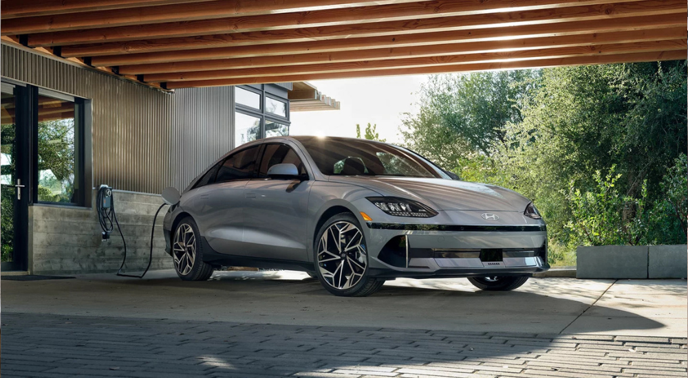 Silver 2026 Hyundai IONIQ 6 parked at an angle in front of a home.