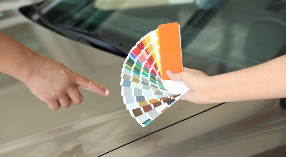 Person pointing at a color swatch booklet
