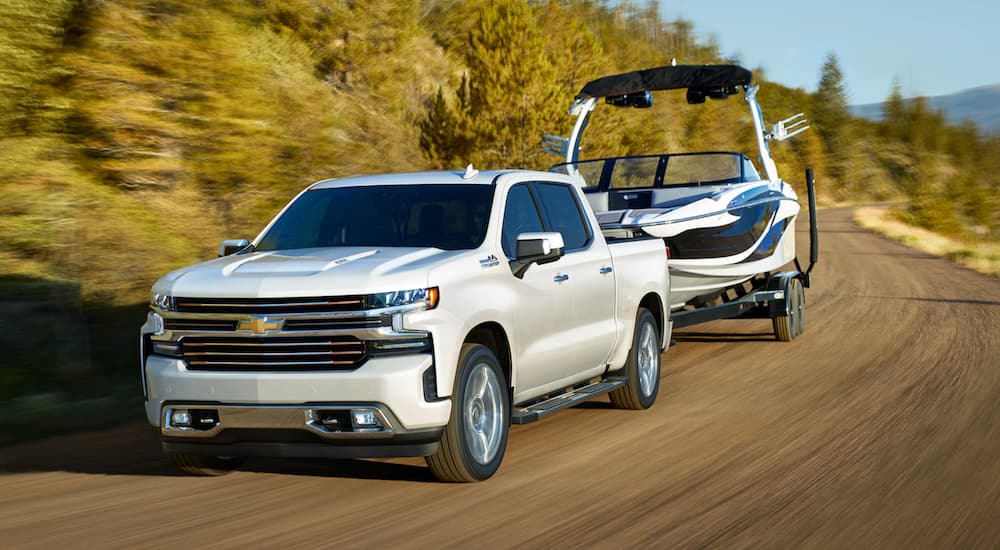 White 2021 Chevy Silverado 1500 towing a boat.