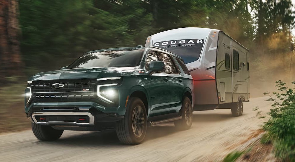 A green 2026 Chevy Tahoe towing a trailer.