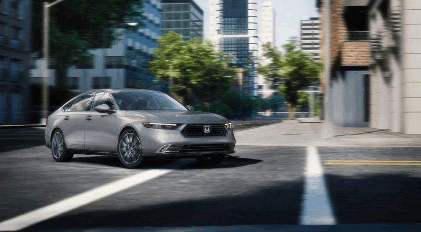 Grey 2025 Honda Accord Hybrid for sale going for a test drive around a city.