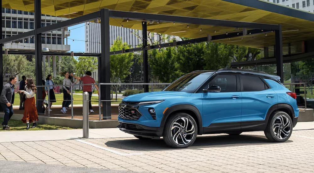 A blue 2024 Chevy Trailblazer RS parked near a used Chevy for sale.