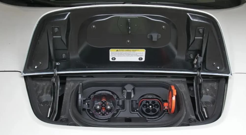 CHAdeMO port on the left and J1772 port on the right on a white vehicle.