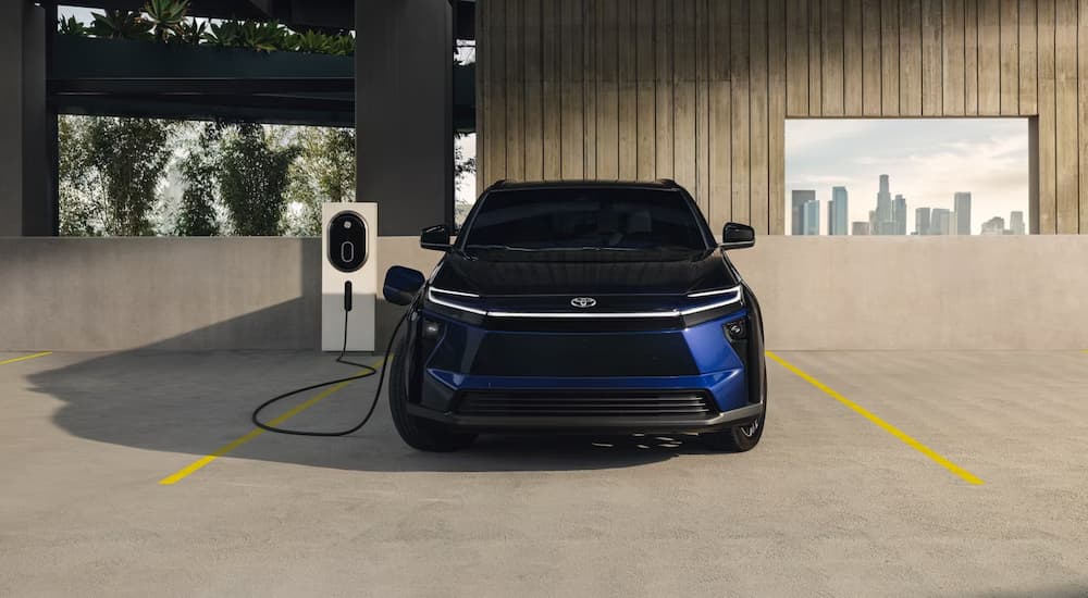 A blue 2026 Toyota bZ plugged in charging