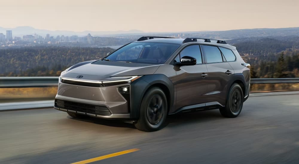 A brown 2026 Toyota bZ Woodland driving down a highway