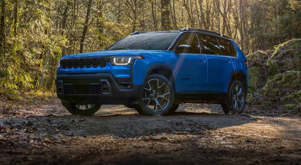 A blue 2026 Jeep Cherokee parked off-road.