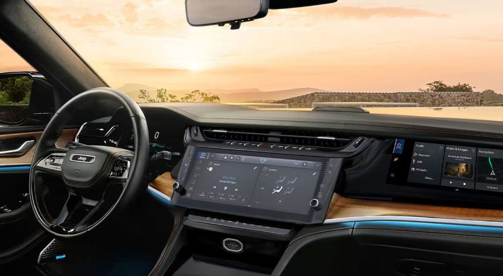 Infotainment displays and steering wheel on a 2026 Jeep Grand Cherokee Summit.