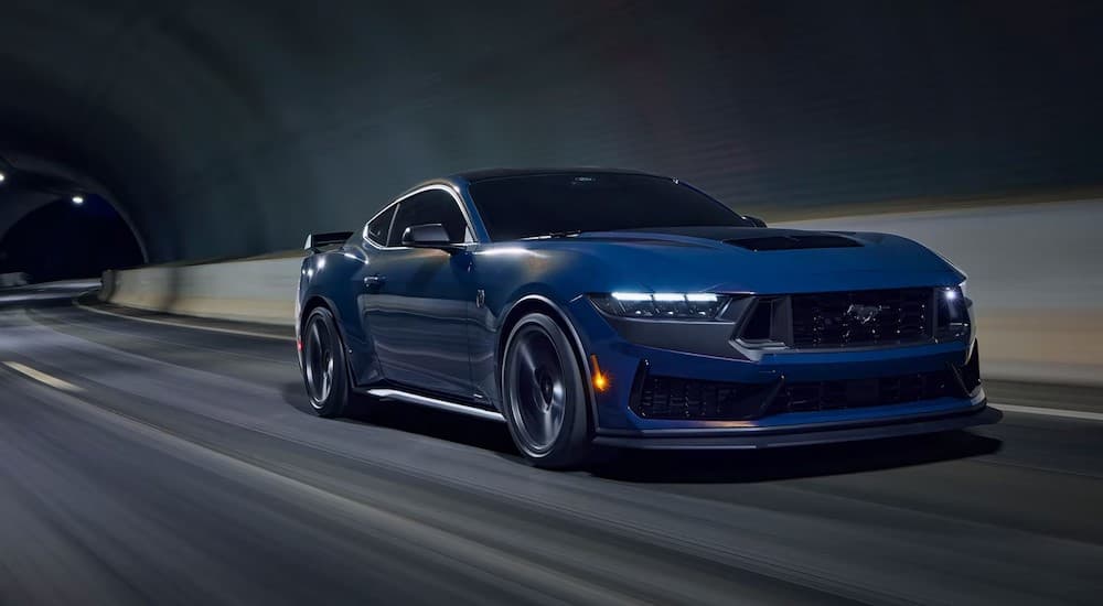 A blue 2024 Mustang Dark Horse Premium driving in a tunnel.