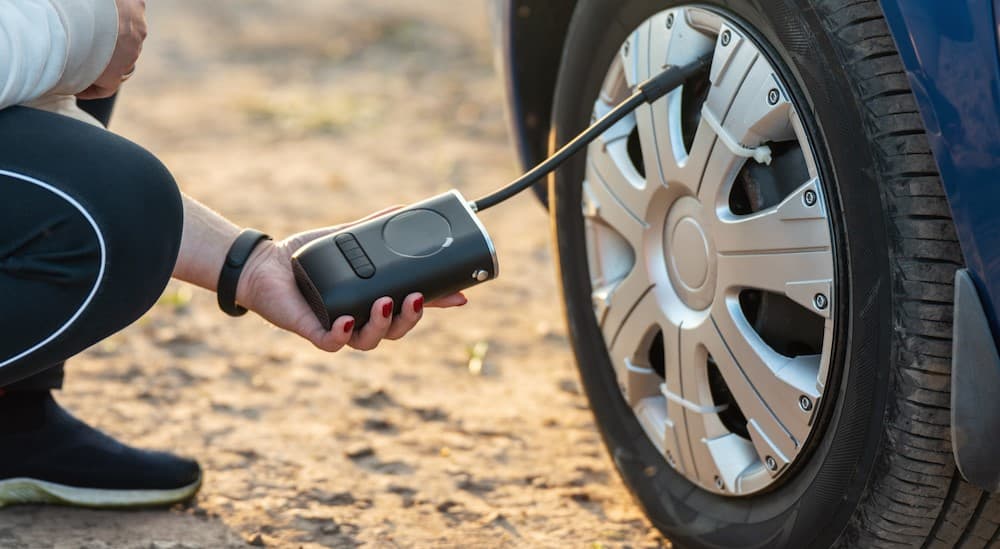 A person holding a portable tire inflator.
