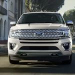 A white 2021 Ford Expedition is shown from the front on a city street after leaving a Ford SUV dealer.