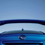 The spoiler on a blue 2020 Subaru WRX is shown from a low angle.